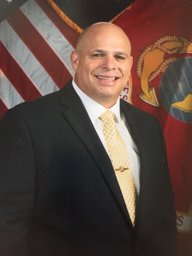 Antony D. Garcia, Founder of TMG2S — a U.S. Marine Corps Veteran, before the United States and Marine Corps colors